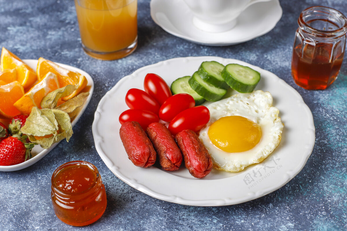 健康早餐盘子里有鸡尾酒香肠 煎蛋 樱桃番茄 糖果 水果和一杯桃子汁咖啡鸡蛋西红柿