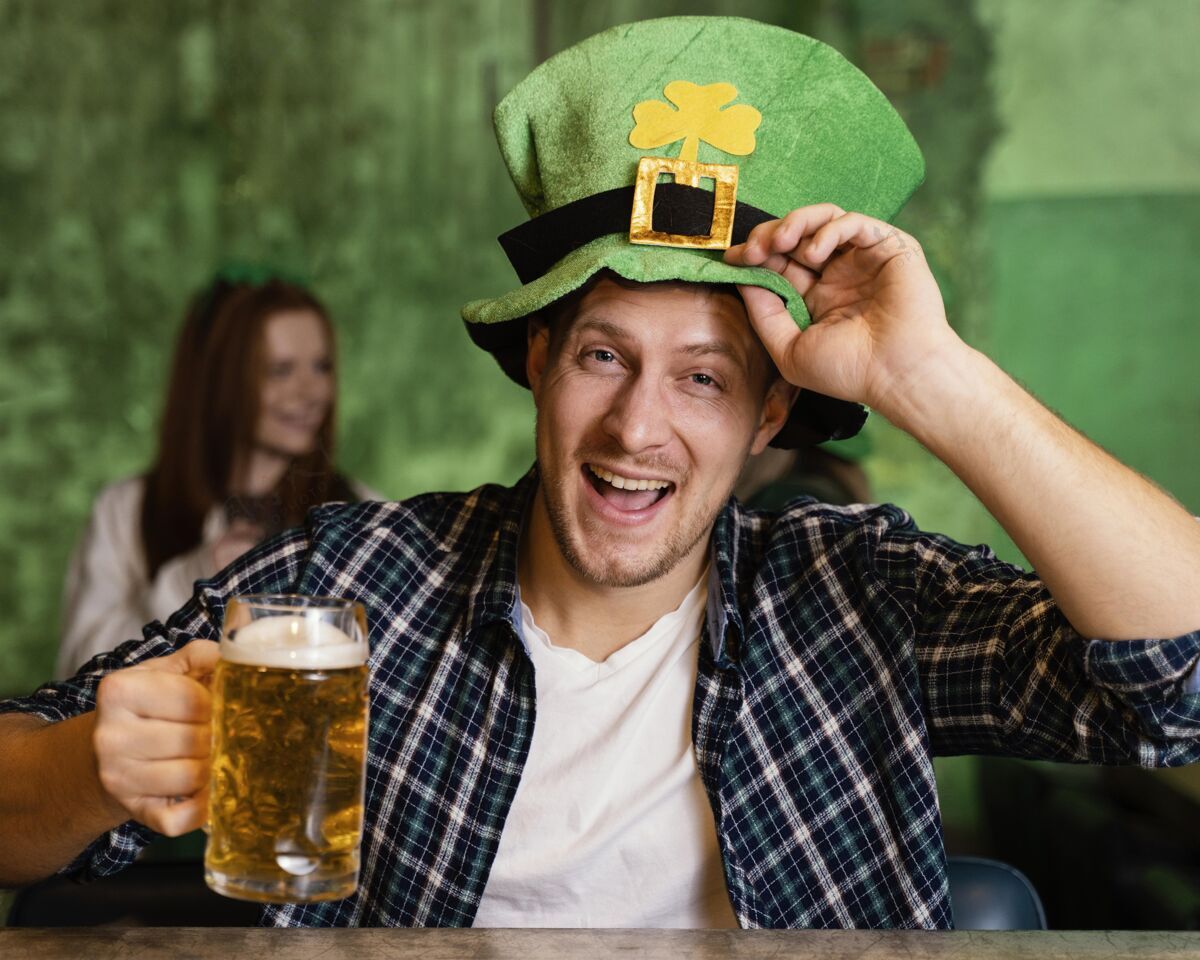 饮料戴帽子庆祝圣帕特里克节的快乐男人的正面图活动三叶草圣帕特里克日