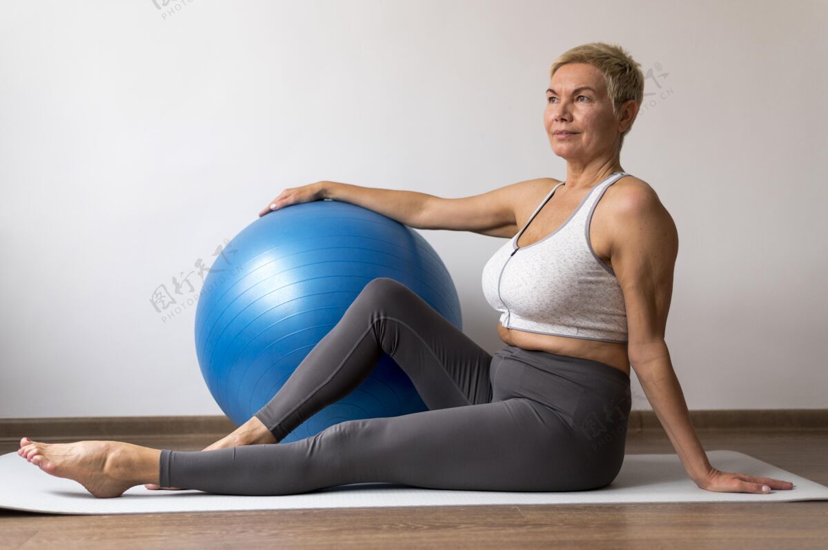健康一位留着短发的高级女士正在使用瑜伽垫有氧运动老年健身