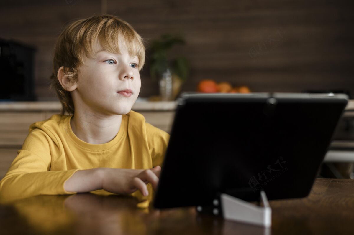 水平男孩在家使用平板电脑的前视图年轻爱好电子