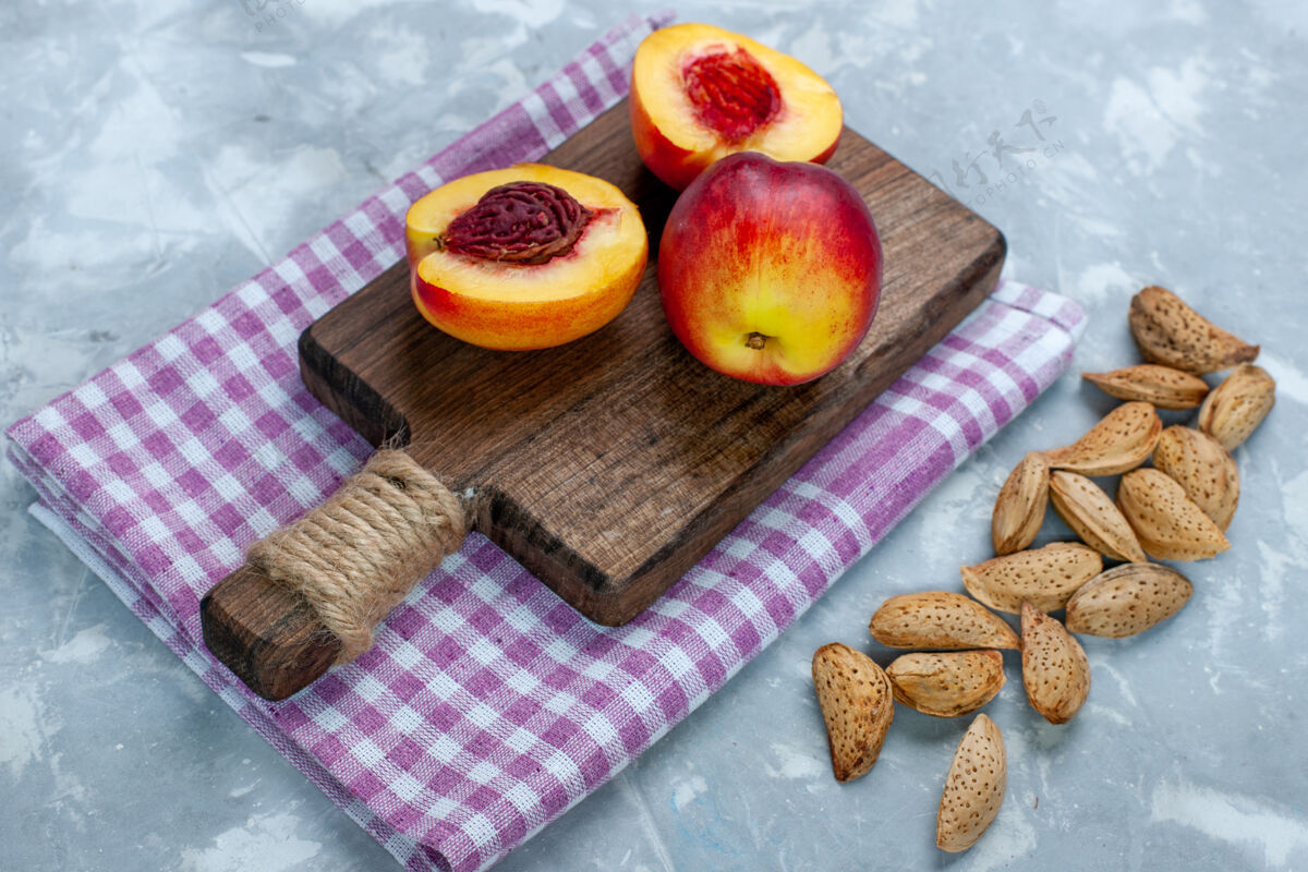 农产品在浅白的桌子上 可以看到新鲜的桃子 醇香可口的水果和坚果健康维生素美味