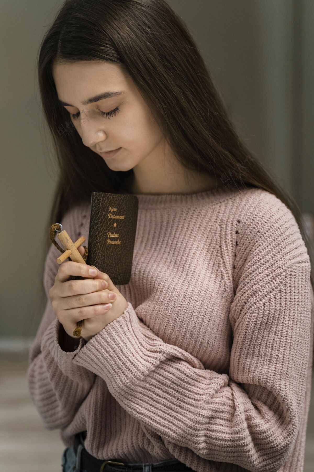 神学女人用木十字架和圣经祈祷灵性崇拜十字架