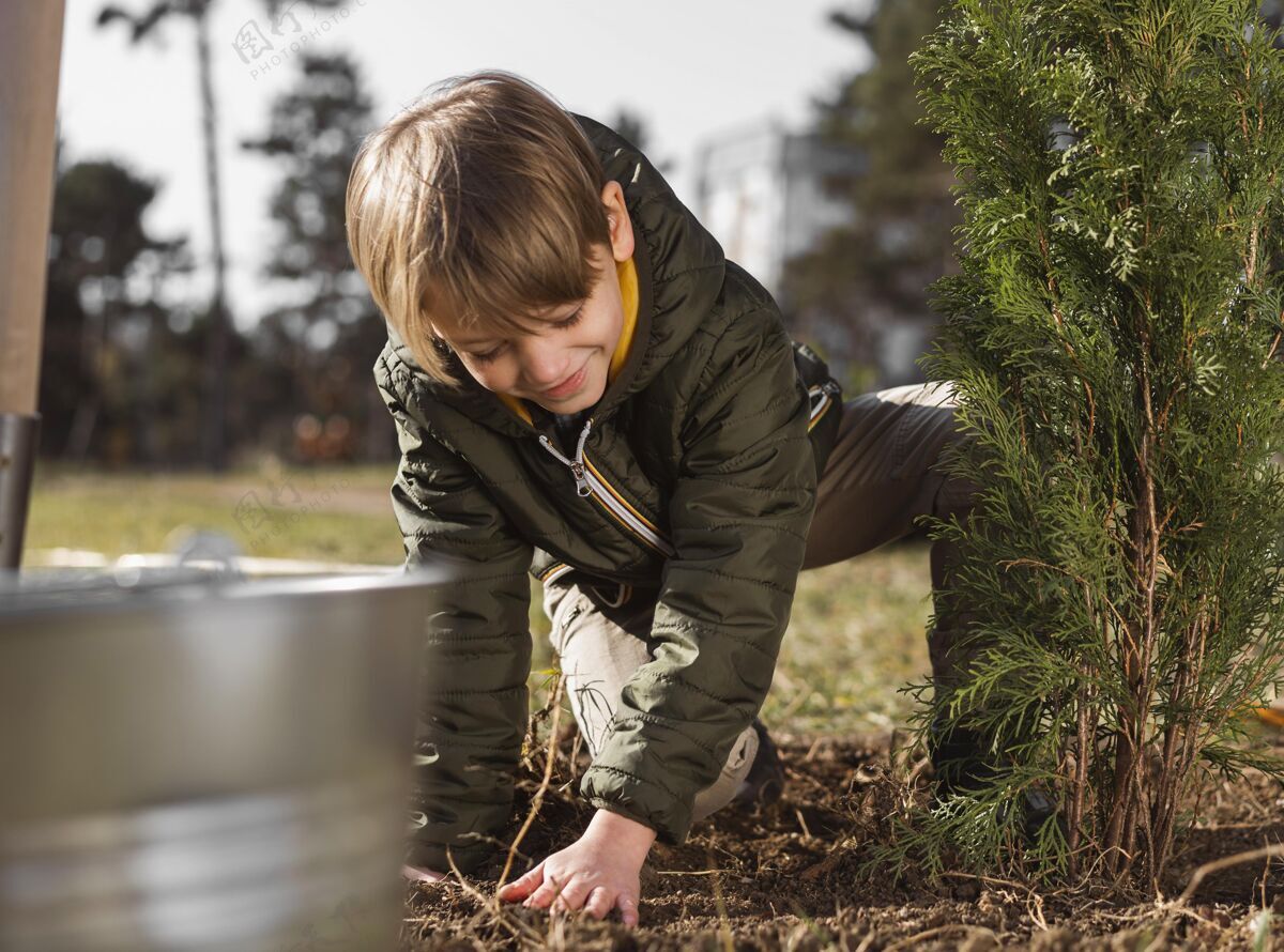 自然小男孩在外面种树水平孩子植物