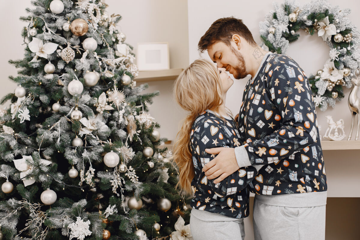 夏娃穿着圣诞老人装潢的人们穿着睡衣的男人和女人一家人在家里女性圣诞浪漫