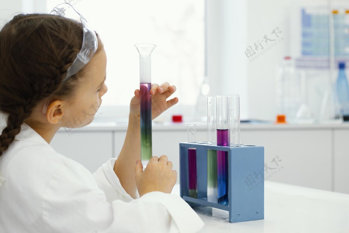 学习戴着安全眼镜的年轻女科学家在实验室做实验学习孩子水平
