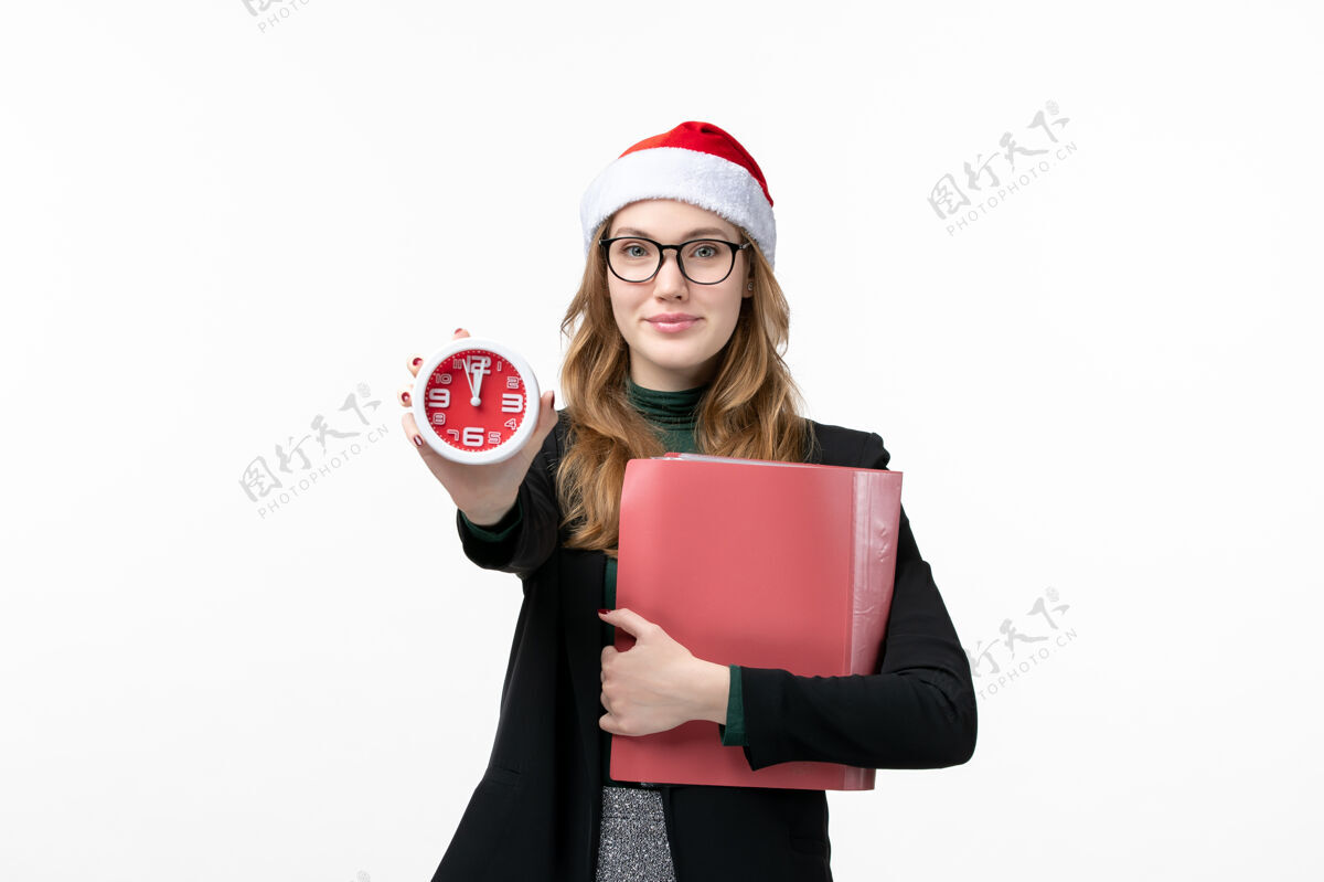 圣诞节正面图年轻女性拿着文件和时钟在白色地板上新年圣诞书快乐年轻女性成人