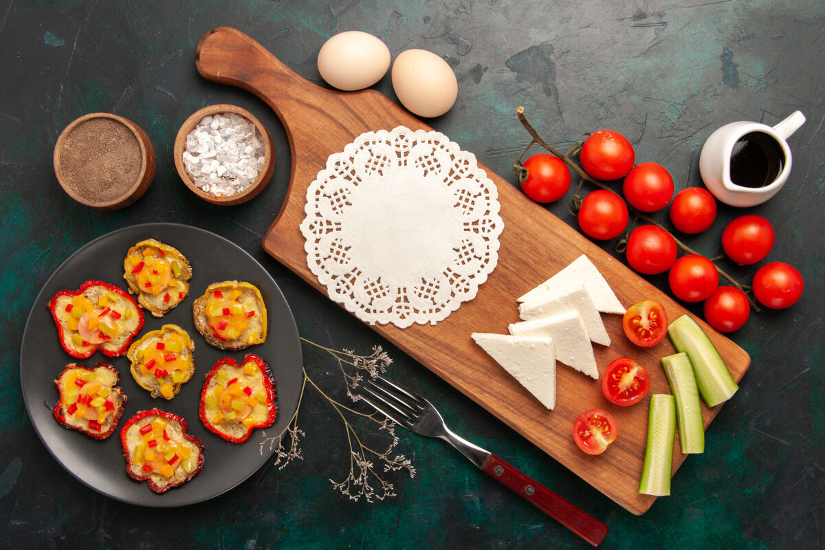 食物顶视图熟蔬菜与生鸡蛋和新鲜西红柿在黑暗的表面蔬菜顶部容器