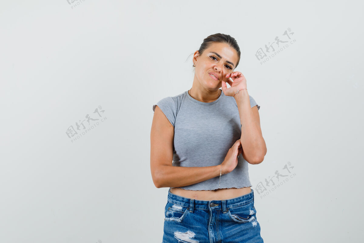 敏感年轻女性穿着t恤 短裤站在思考的姿势 看起来很理智T恤积极专业