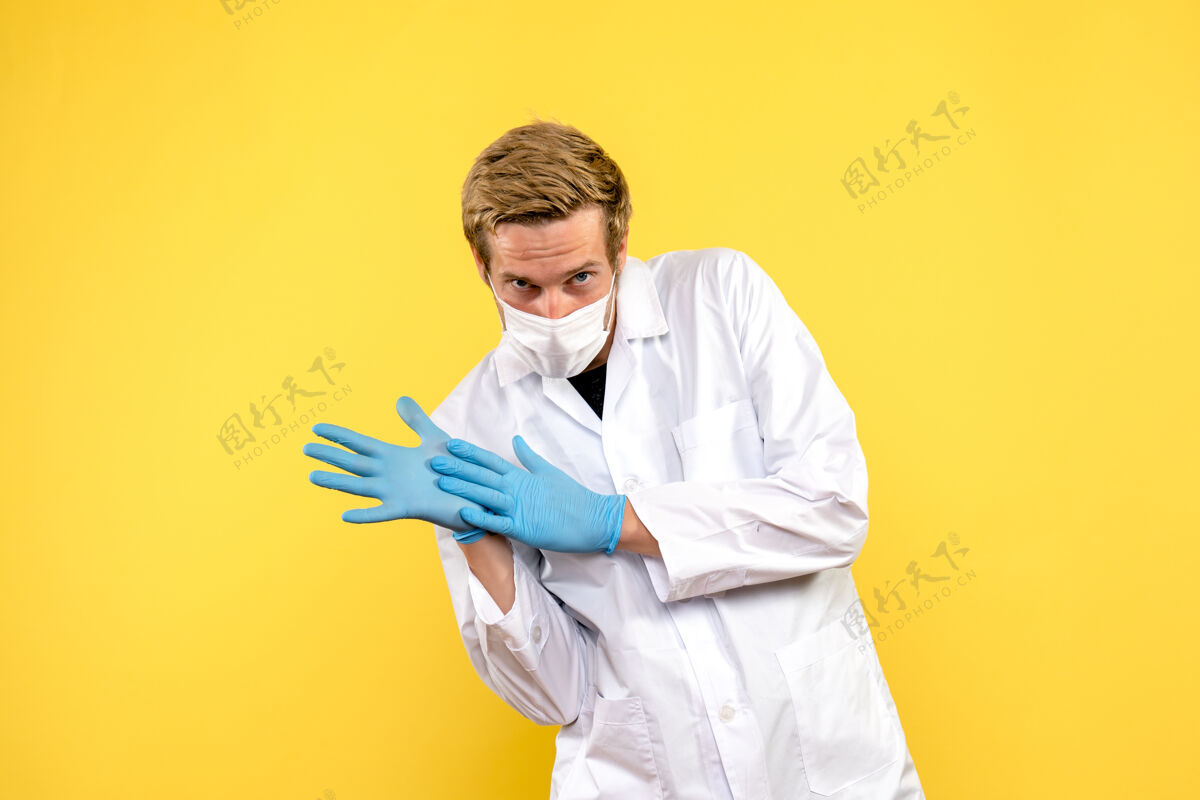 医学正面图男医生正站在黄色背景上健康医生大流行病毒男性医生前面微笑