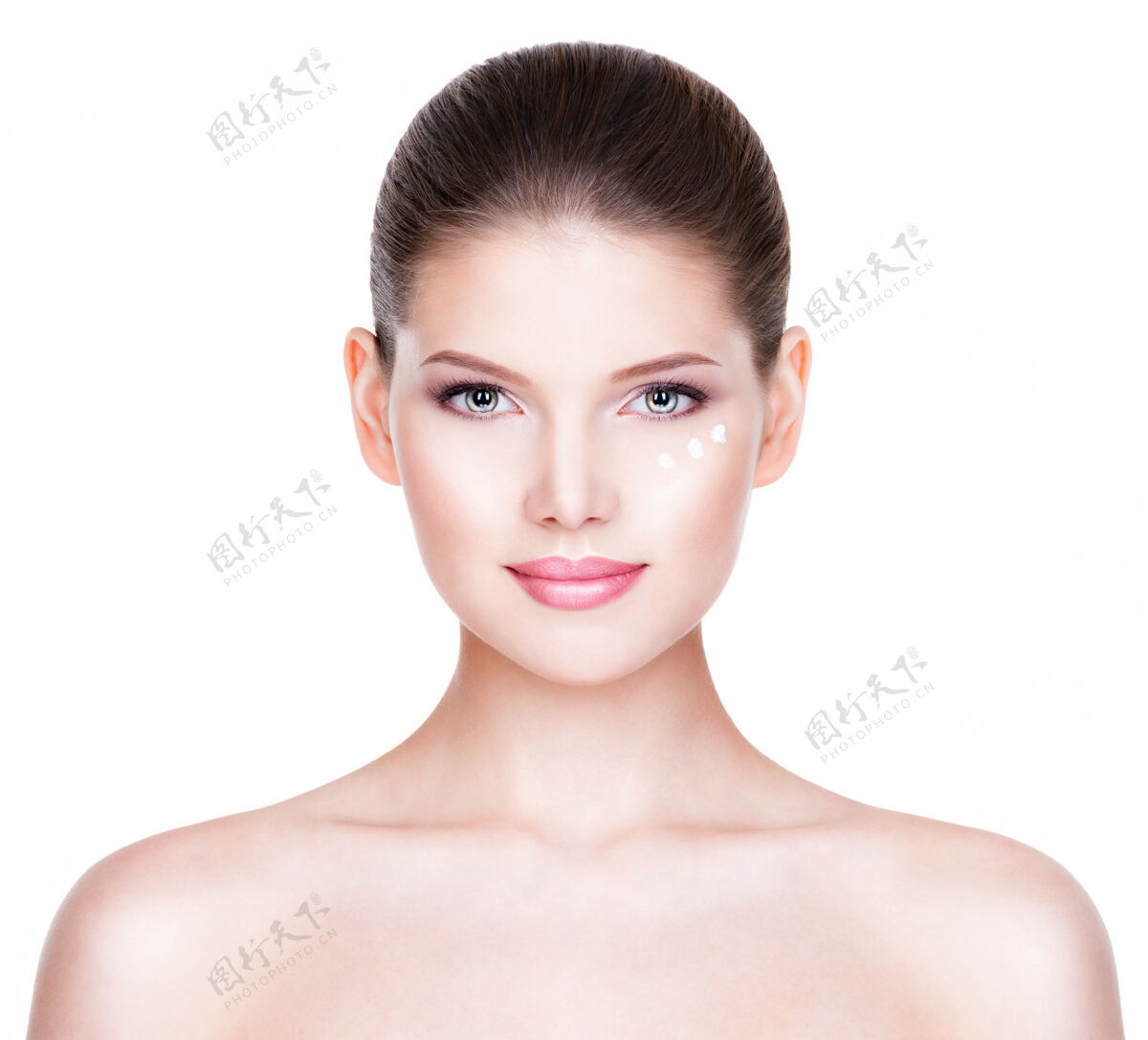 年轻健康美丽的女人的画像 眼睛下面涂着化妆霜-隔离在白色上眼睛清洁肖像