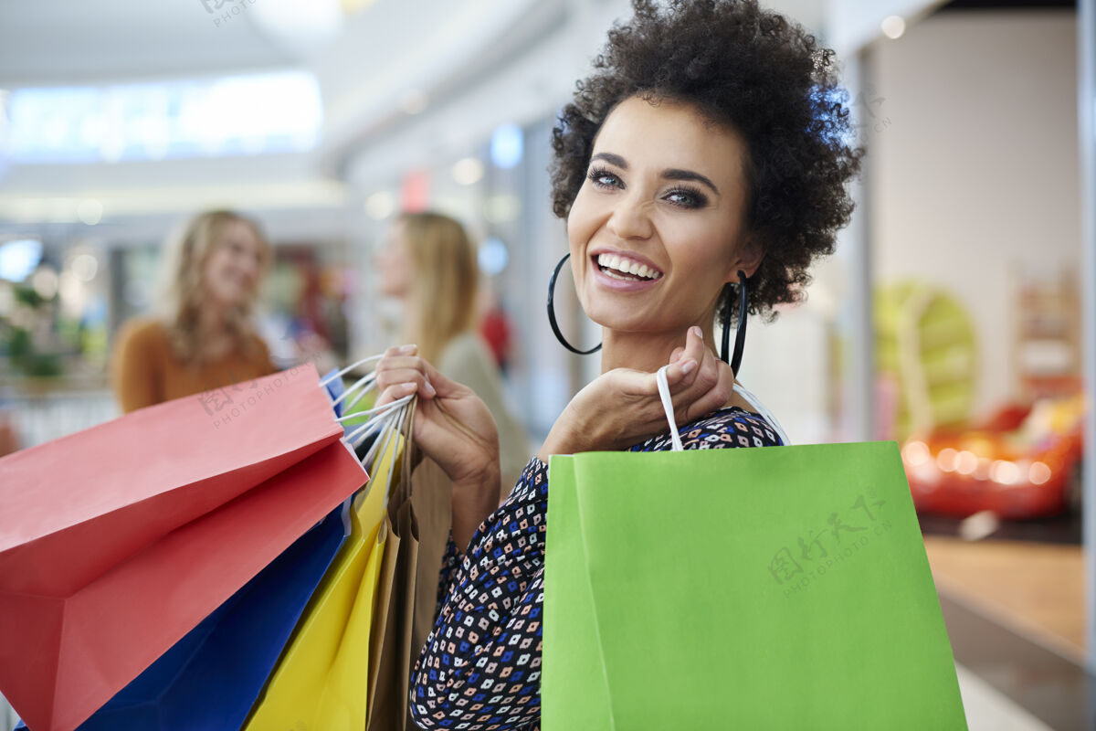 购物中心购物袋满满的快乐女人朋友商场背景的人