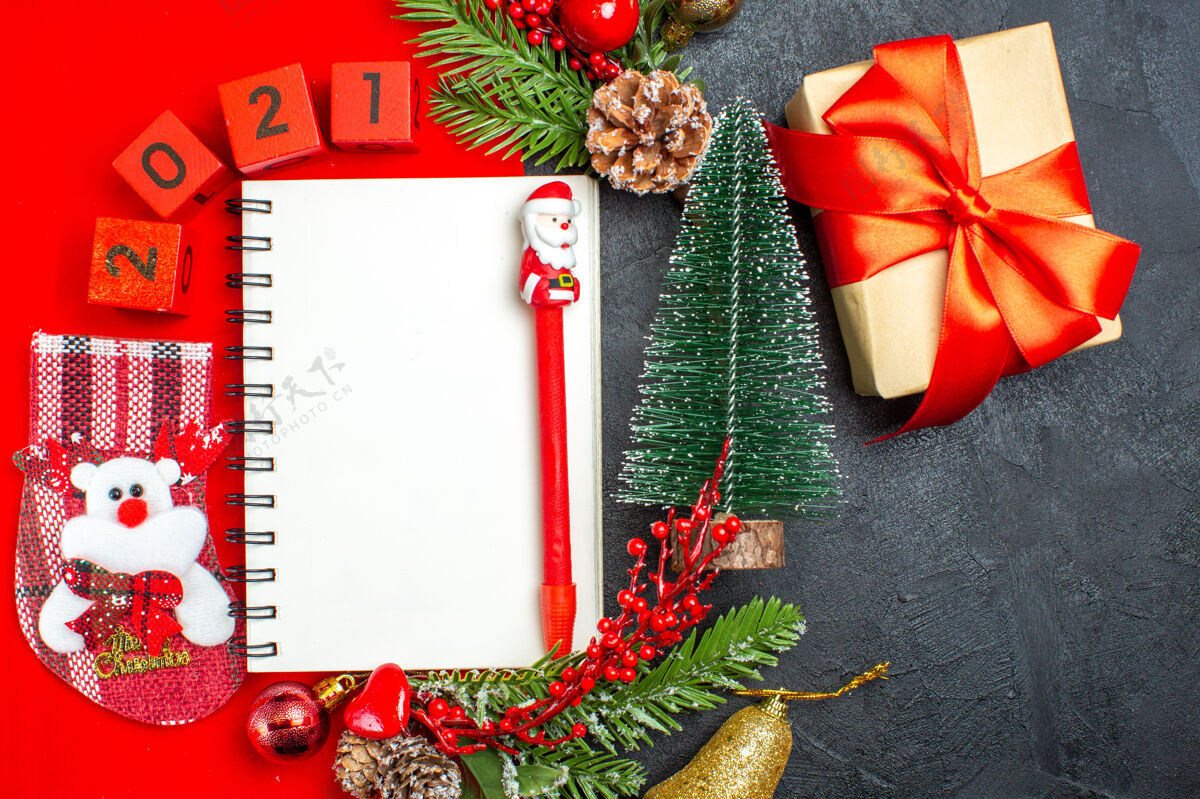 餐巾上图为黑色背景上的螺旋笔记本装饰配件杉木树枝xsmas袜子编号红色餐巾和礼物圣诞树圣诞冬青数字