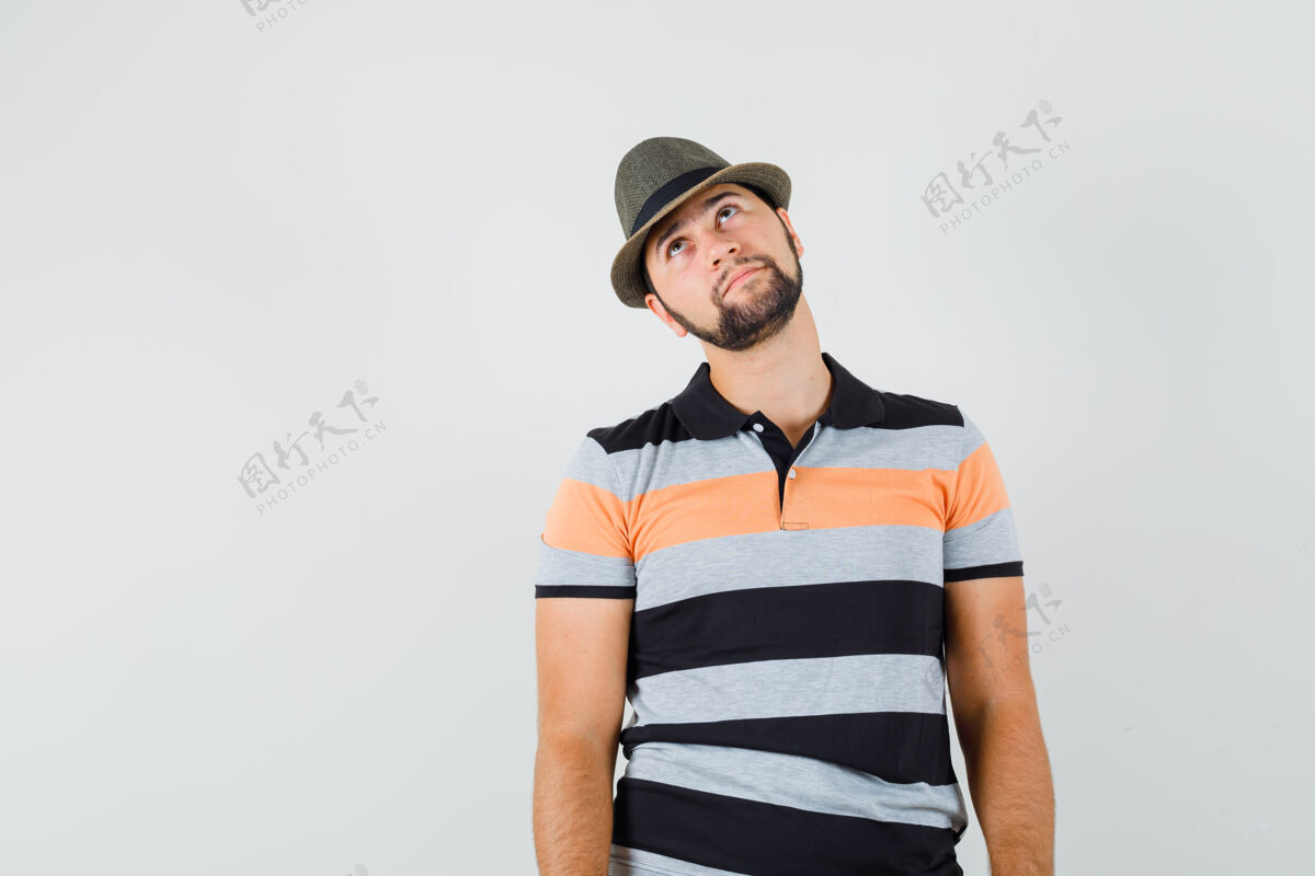 休闲年轻人穿着t恤 戴着帽子向上看 看上去很体贴 前视图帅哥自信帽子