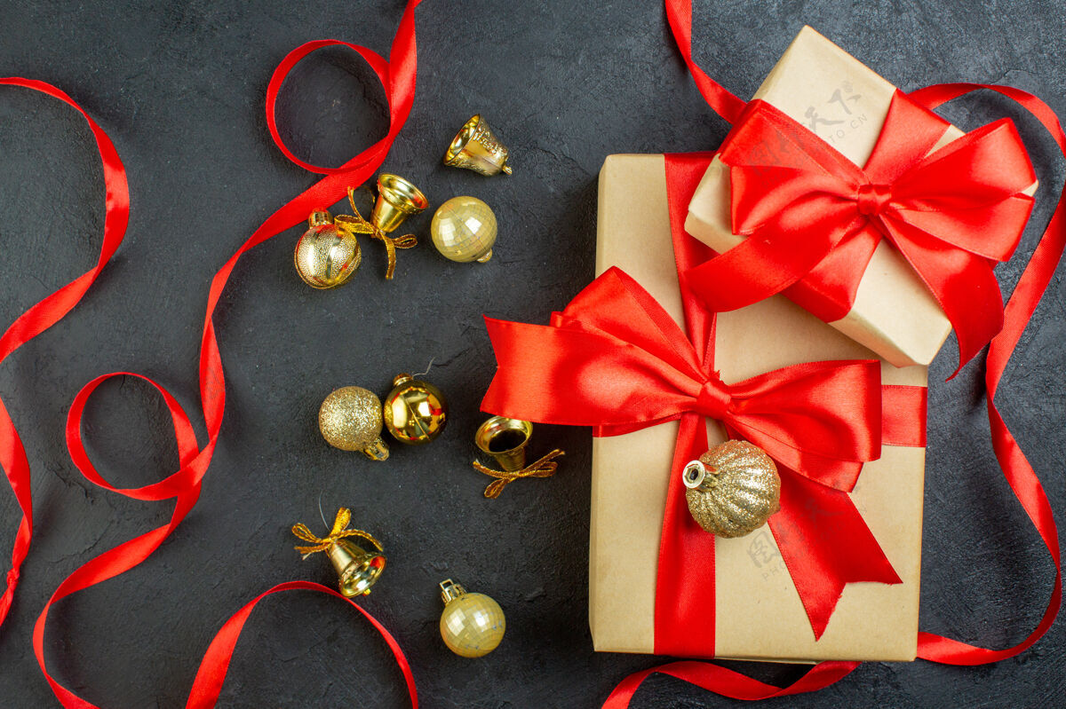 礼品盒黑色背景上带有红丝带和装饰配件的礼品盒俯视图圣诞节头顶视图