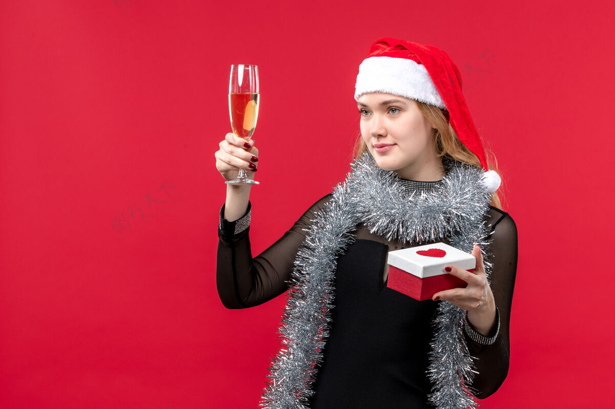 风景正面图年轻女性带着礼物庆祝红桌假日彩色圣诞节书桌漂亮帽子