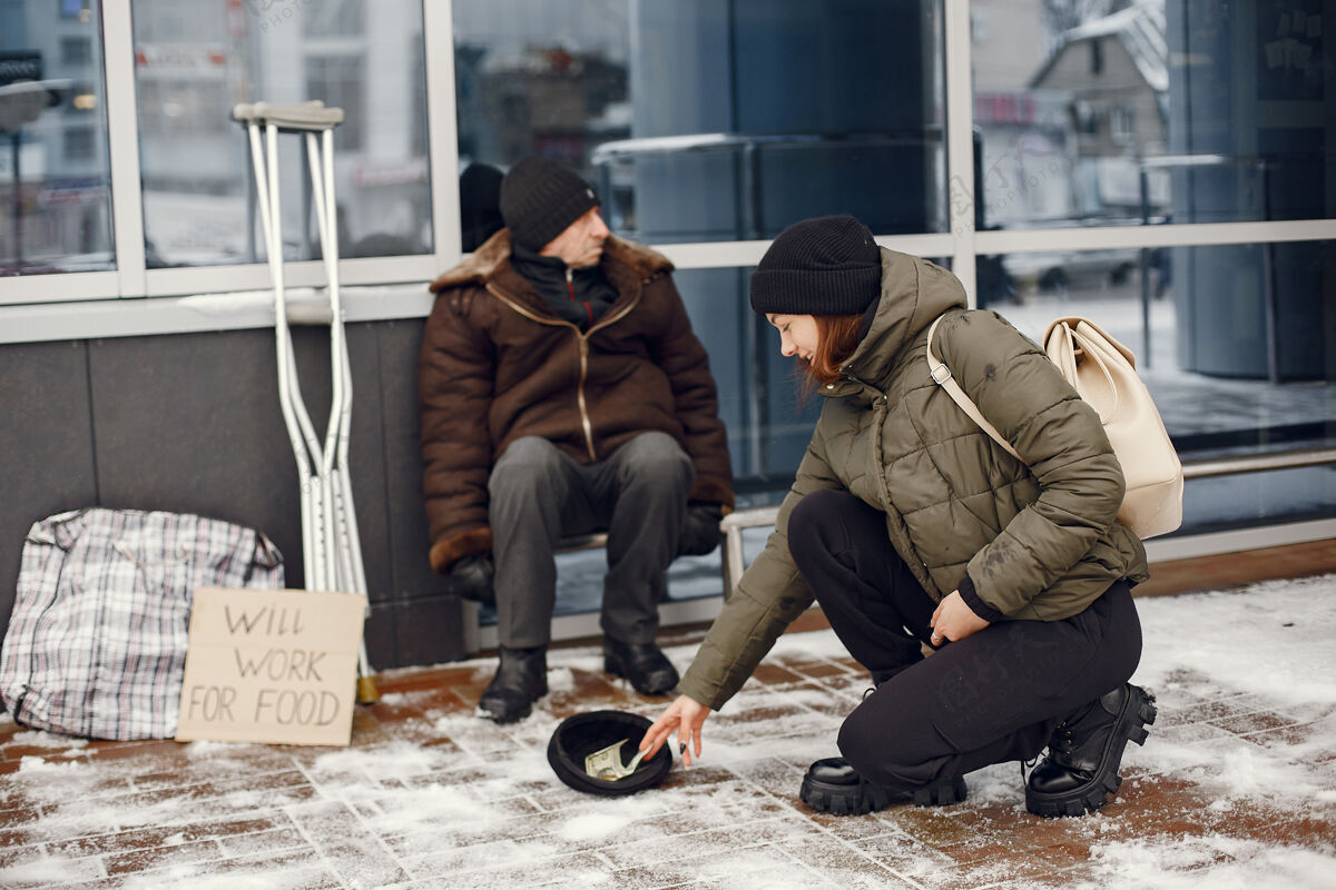 帮助在一个冬天的城市里无家可归有人要食物户外社会帽子