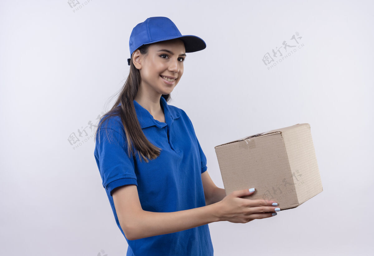 拿着穿着蓝色制服和帽子的年轻送货女孩抱着盒子微笑着自信送货制服女孩