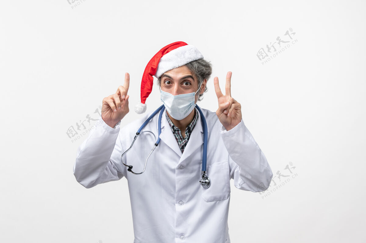 加强正面图：男医生带着无菌口罩在白墙上新年病毒大流行背带绝育大流行