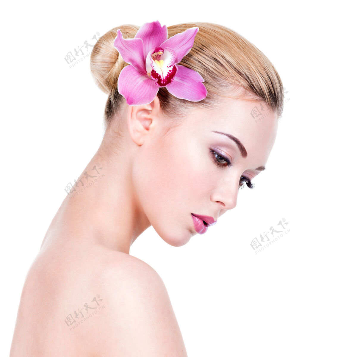 化妆年轻漂亮女孩的特写肖像 脸旁有花-隔离在白墙上模特护理治疗