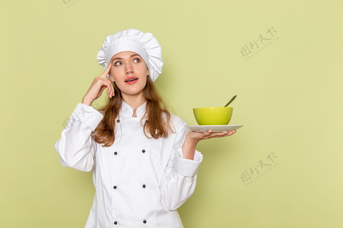 厨房身穿白色厨师服的女厨师正拿着绿色盘子 绿色墙上摆着盘子淋浴封面女厨师