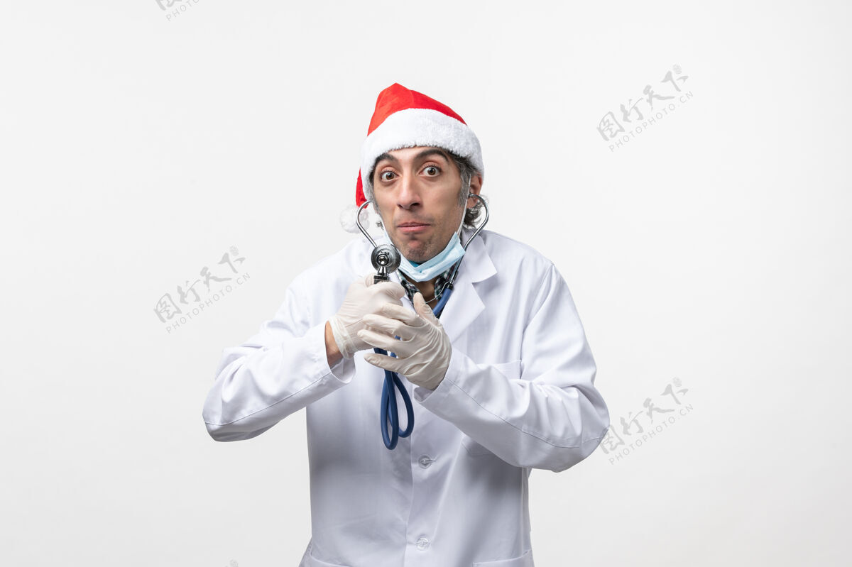 圣诞节前视图男性医生用听诊器感染病毒听诊器制服病毒