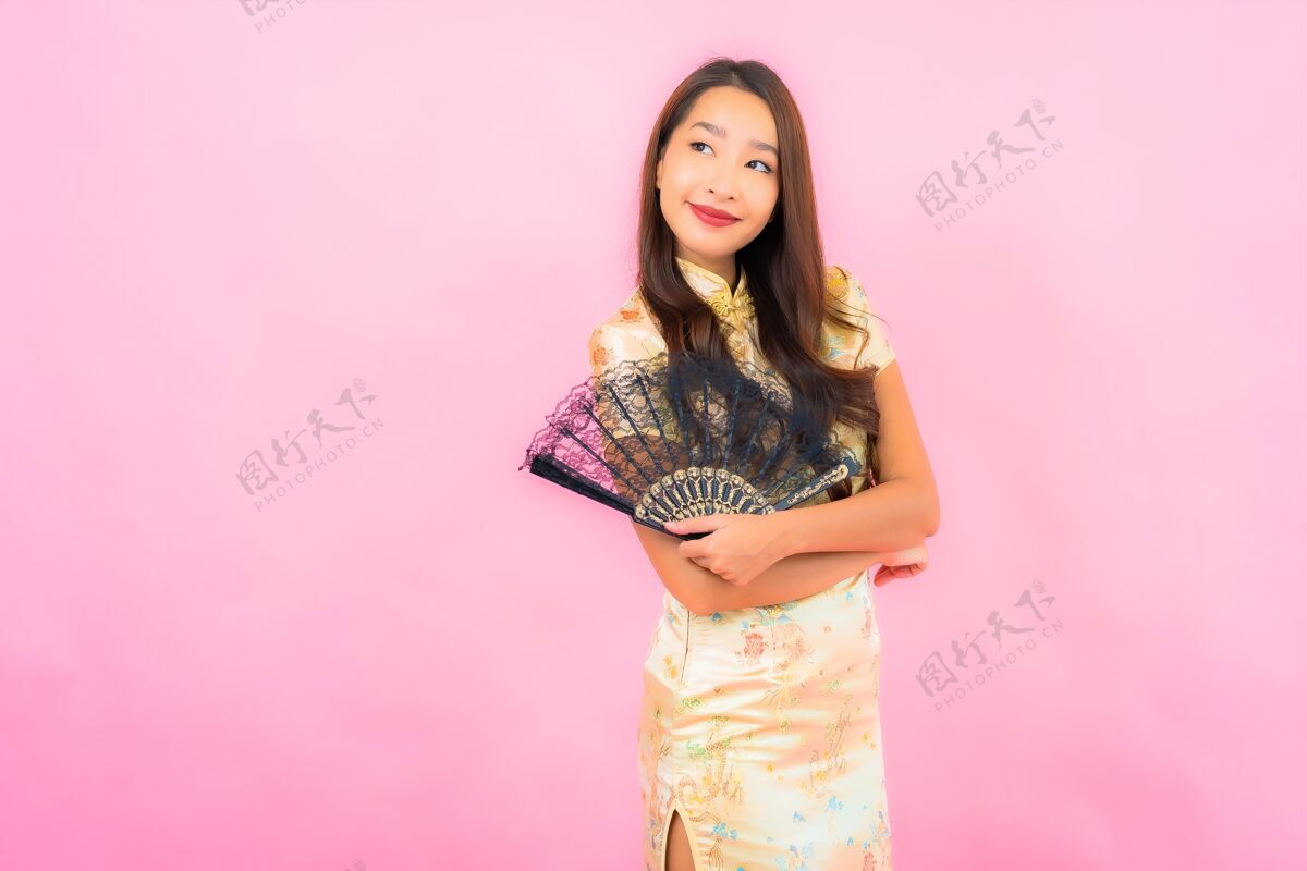 人用中国新年概念和彩墙扇子描绘美丽的亚洲年轻女子东方人站立传统
