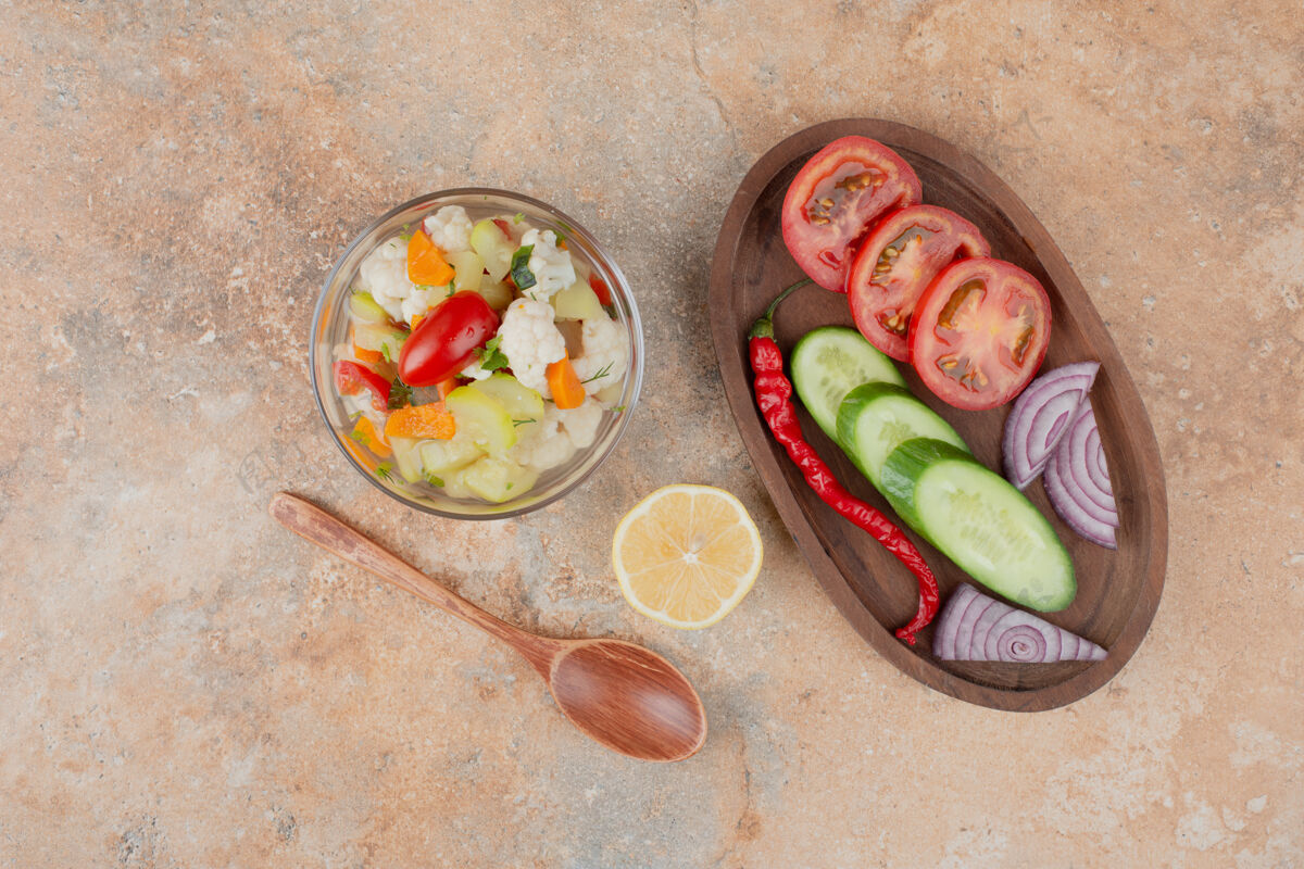 好吃美味的蔬菜放在玻璃板上 番茄 黄瓜和洋葱木板放在大理石表面玻璃杯盘子好吃