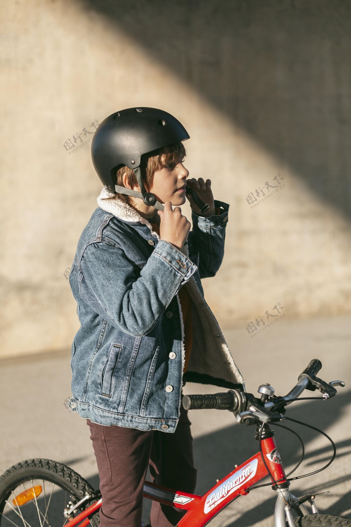 放松戴着安全帽的男孩骑自行车的侧视图活动自行车休闲