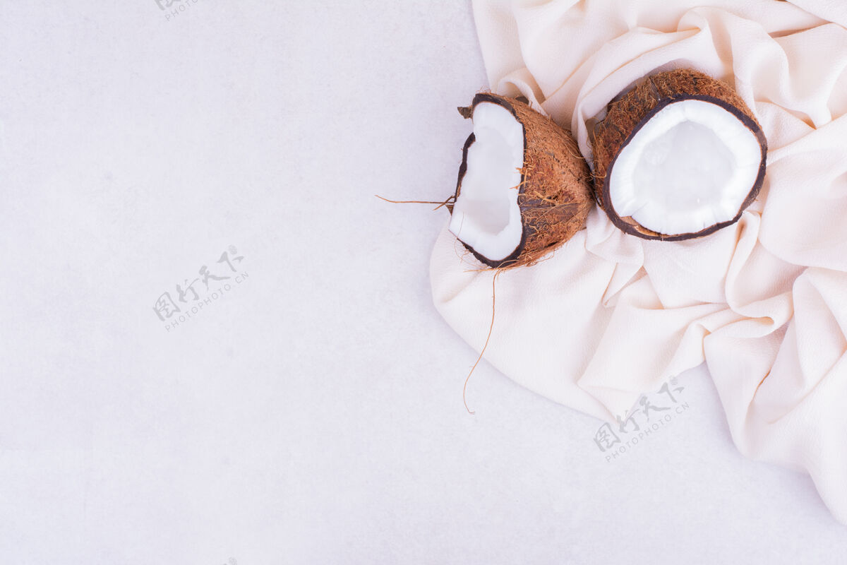 产品椰子在米色桌布上碎成两块美味食物美味
