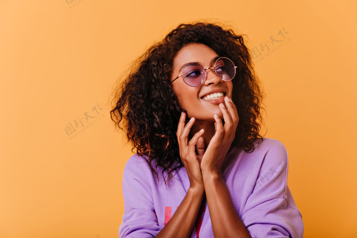 黄色好奇可爱的女孩戴着紫色眼镜摆姿势室内拍摄的幸福的非洲女人表达积极的情绪黑色乐趣非洲