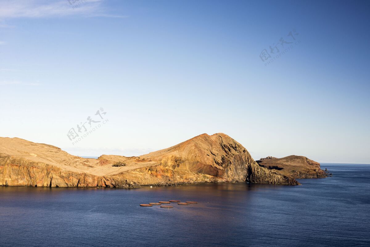 辉光阳光下岩石环绕的大海和葡萄牙白天的蓝天岩石天空风景