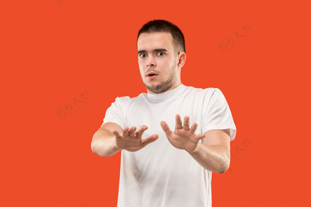模型害怕的男人的画像男人孤立地站在时髦的橙色上情绪化尖叫站着