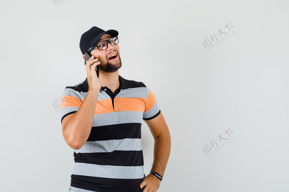 胡须一个穿着t恤 戴着帽子 兴高采烈地打电话的年轻人自信T恤发型