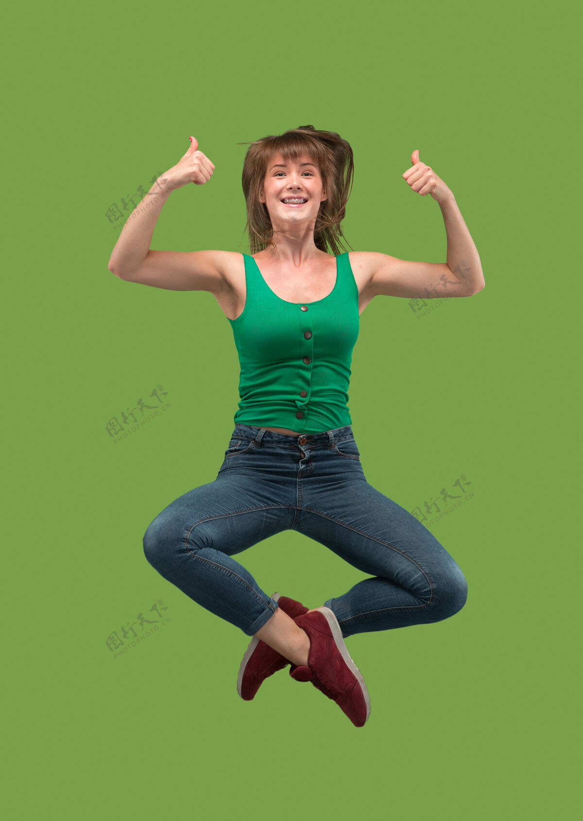 舞蹈在移动的自由相当快乐的年轻女子跳跃和绿色的手势空中拍摄活动跑步长度
