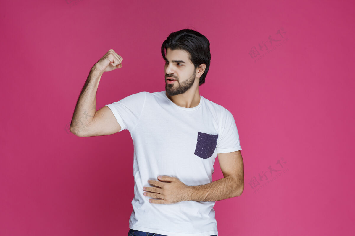 员工在粉红色的墙上 男人看起来积极而冷酷年轻人服装快乐