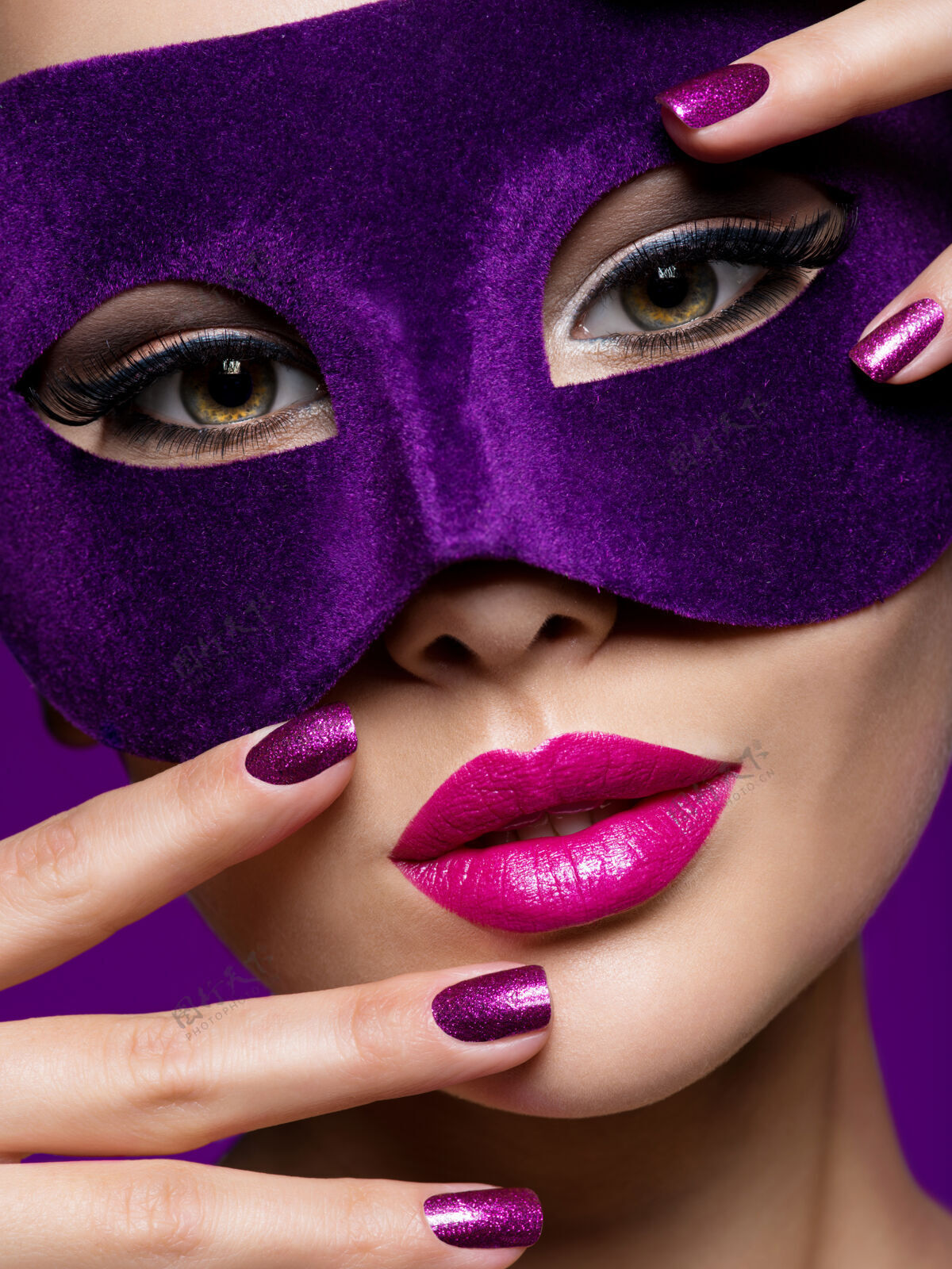 紫色背景一个戴着紫罗兰色指甲和戏院面具的美丽女人的肖像魅力化妆面部