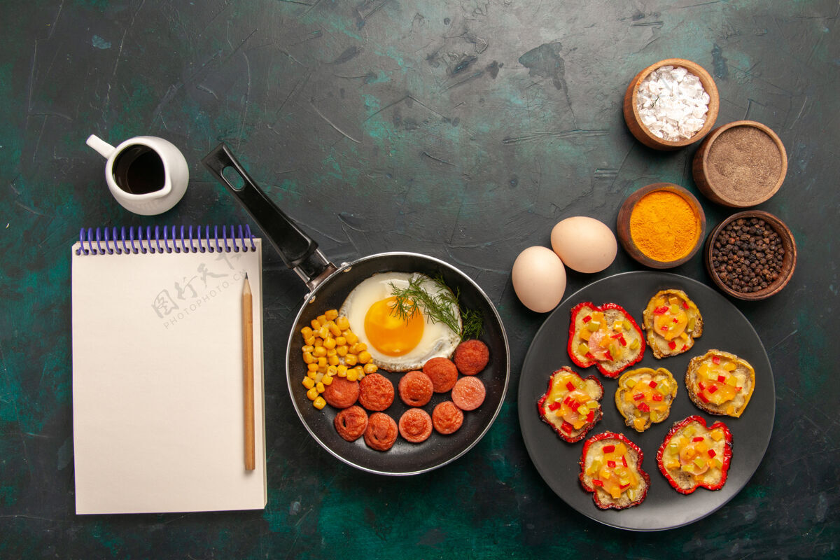 蔬菜顶视图炒鸡蛋与香肠和不同的调味品在黑暗的背景薯条早餐午餐