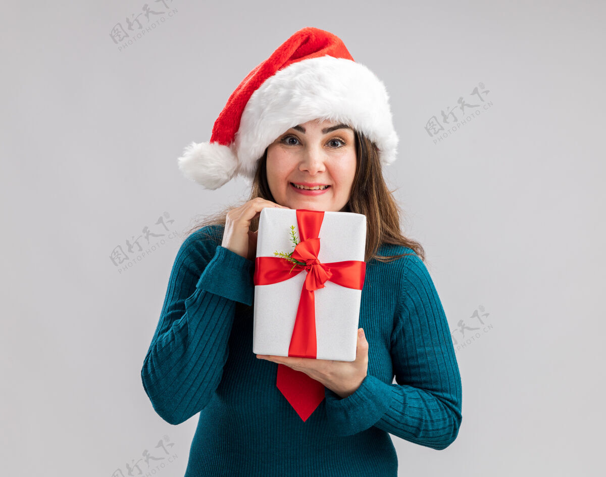 帽子高兴的成年白人妇女与圣诞帽和圣诞领带举行圣诞礼品盒圣诞快乐新年领带