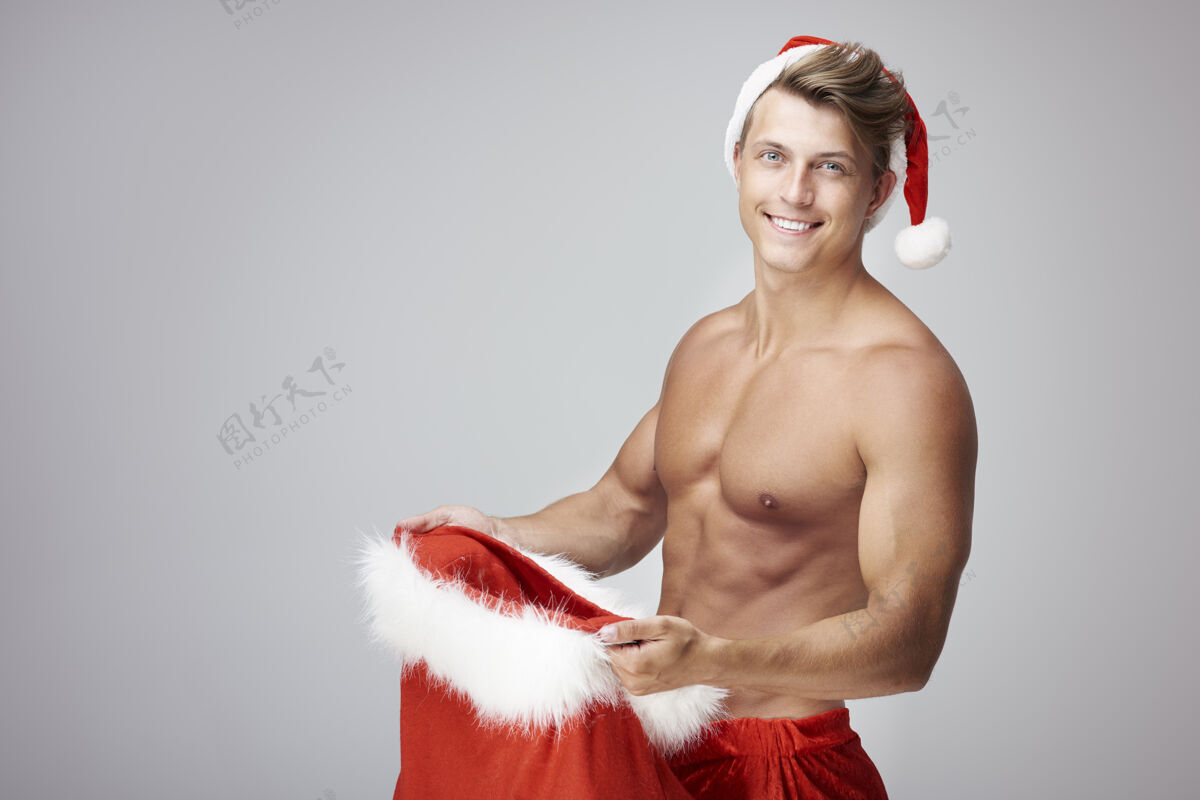 圣诞老人帅哥和装满圣诞礼物的袋子打开头发裸体