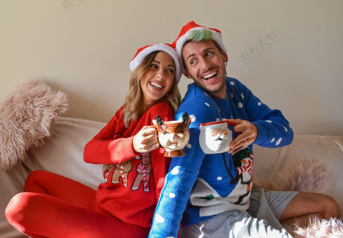 男人拍摄一对幸福的夫妇在圣诞节小屋和衣服举行有趣的杯子礼物浪漫传统
