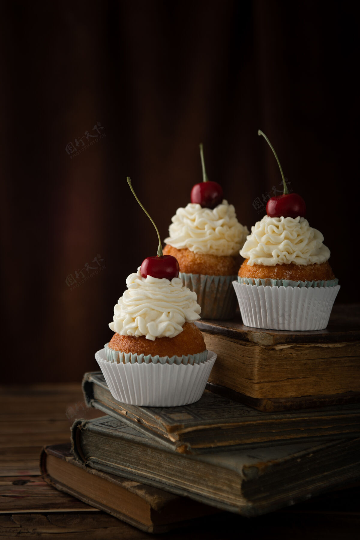 糖垂直拍摄美味的纸杯蛋糕奶油和樱桃上的复古书籍蛋糕垂直美味