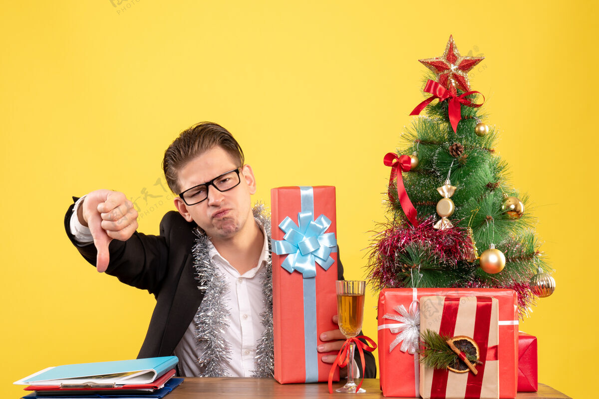 颜色正面图：男工人拿着圣诞礼物坐着假期生活工作