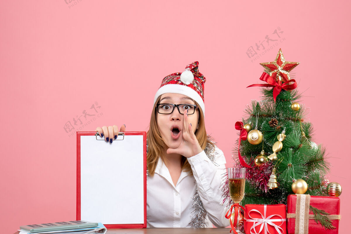 圣诞节女工正坐在粉红色的文件上女工人情感坐