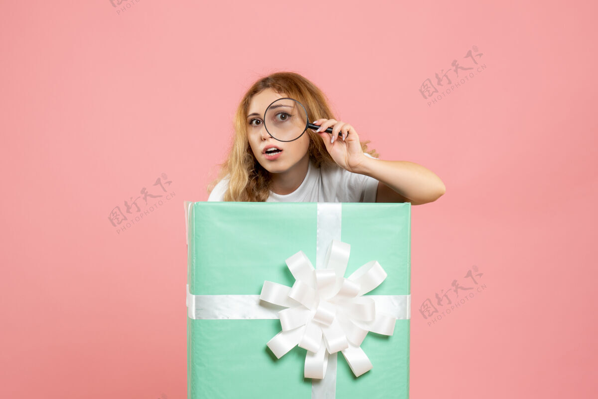 放大镜前视图年轻女性在蓝色礼品盒内使用放大镜睡眠女性内部