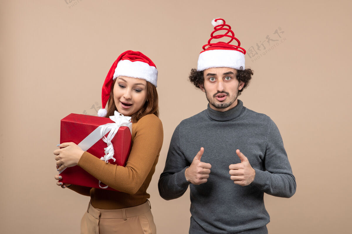 帽子新年气氛喜庆的概念与有趣可爱的夫妇戴着红色圣诞老人帽的灰色镜头圣诞节孩子男人