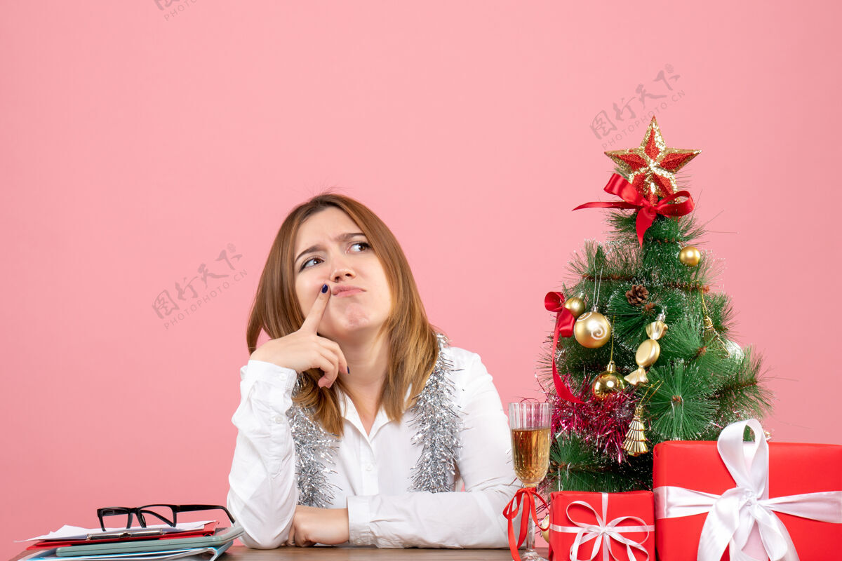 女性女工围坐在粉色的圣诞礼物旁的正视图礼物圣诞节成人