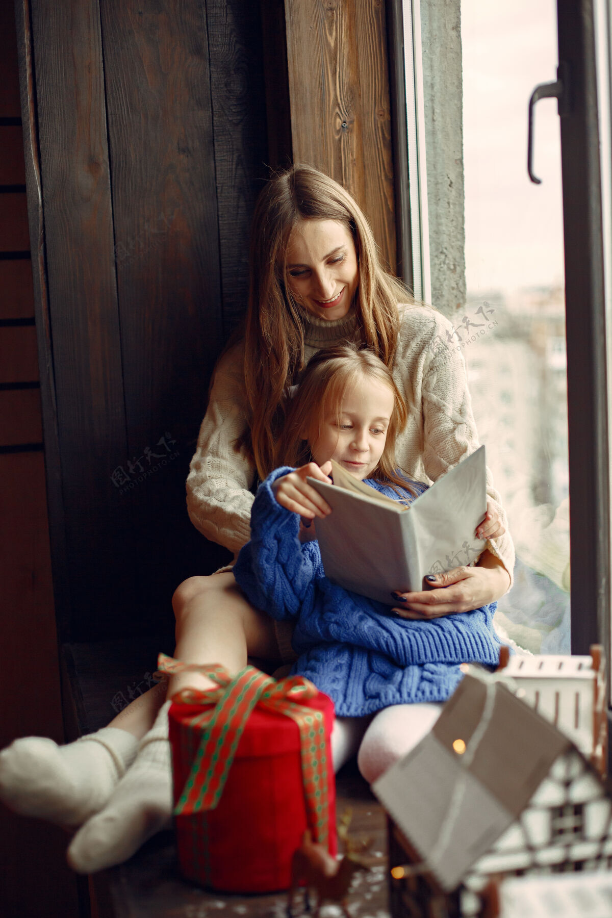 圣诞节人们在为圣诞节做准备母亲在和女儿玩耍一家人在节日的房间里休息孩子穿着蓝色毛衣装饰孩子装饰