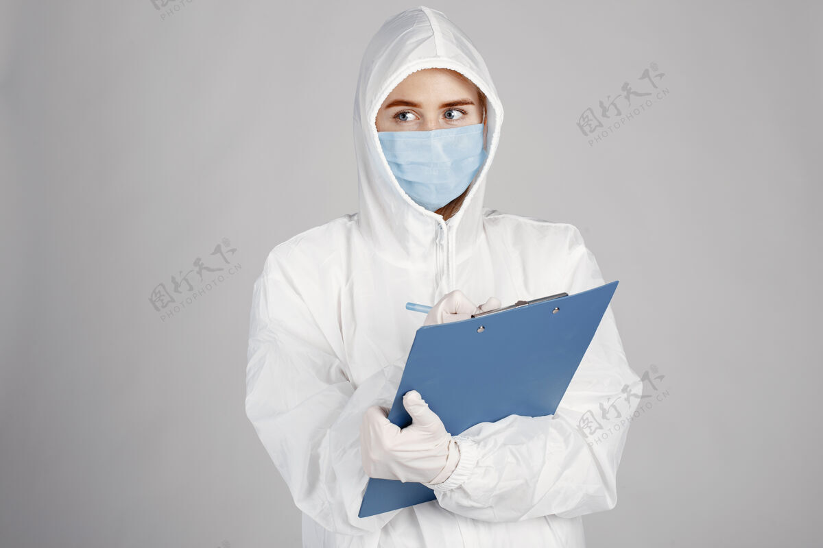 制服戴着医用面罩的医生冠状病毒主题隔离在白墙上穿着防护服的女人文件夹临床从业者