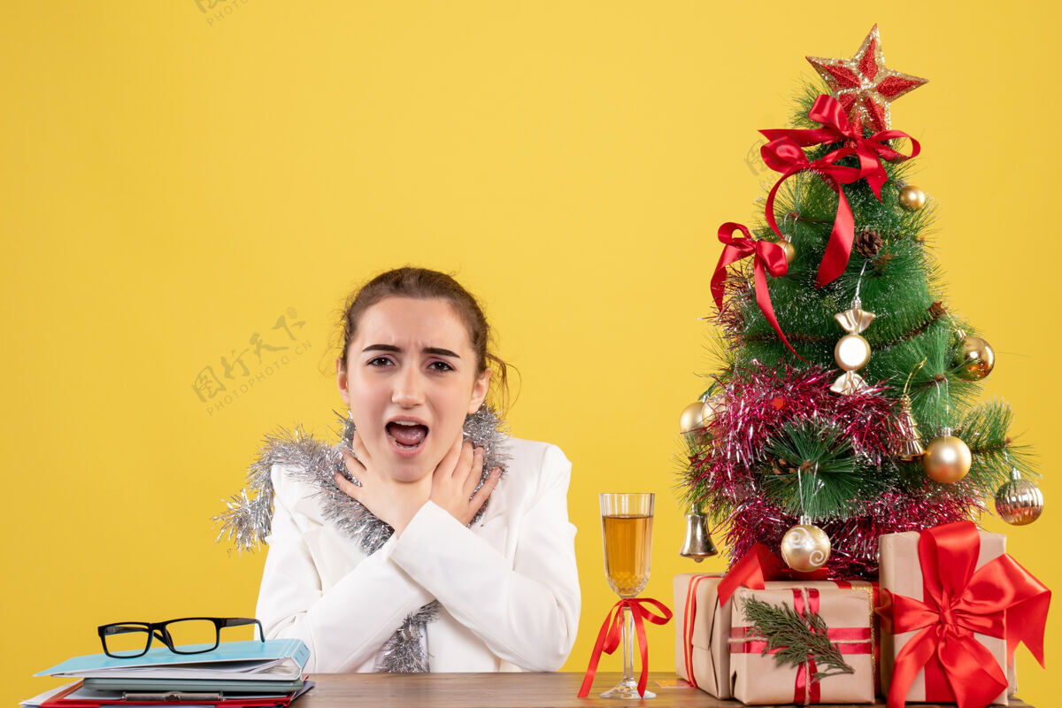插花正面图黄色背景节日色彩圣诞新年情绪护士 女医生坐在桌子后面呼吸困难背景医生护士