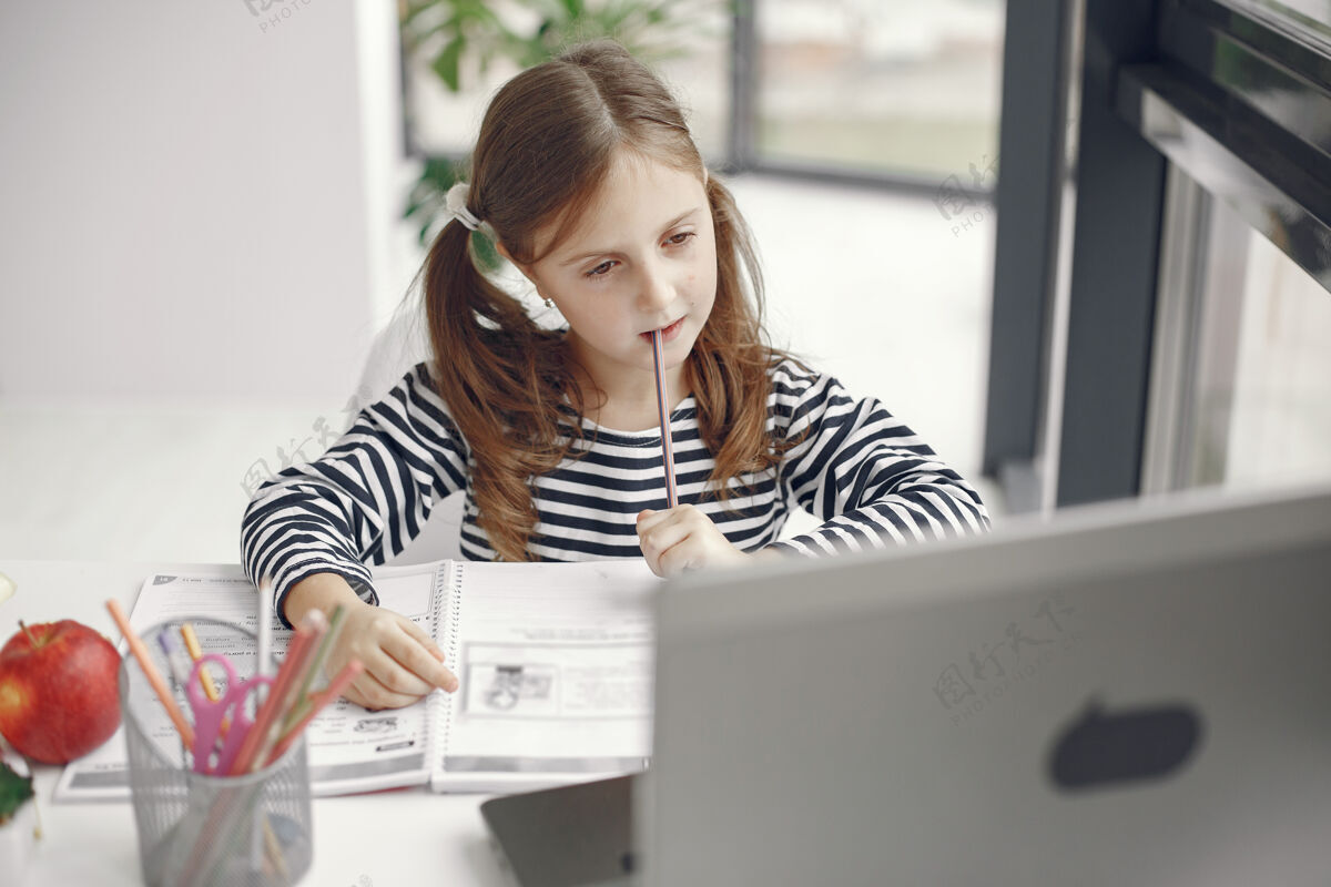 笔记本电脑十几岁的女孩看笔记本电脑流行期间隔离隔离期的孩子家庭教育社交距离在线学校测试阅读家庭作业肖像